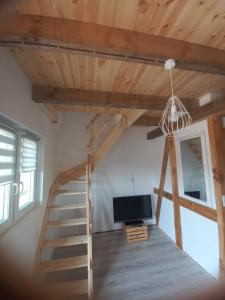 a living room with a staircase and a tv at Zagroda Nadmorska Brzezina in Jastrzębia Góra