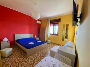a bedroom with a blue bed and a red wall at Sea View - Beautiful Terrace with BBQ in Triscina