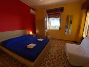 a bedroom with a blue bed with two towels on it at Sea View - Beautiful Terrace with BBQ in Triscina