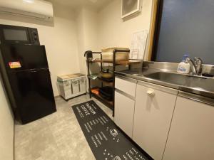 東京的住宿－commun ryogoku - Vacation STAY 96357v，厨房配有水槽和黑冰箱。