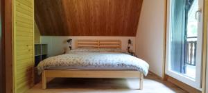 - une chambre avec un lit et une tête de lit en bois dans l'établissement Koča Kresnica, à Ilirska Bistrica