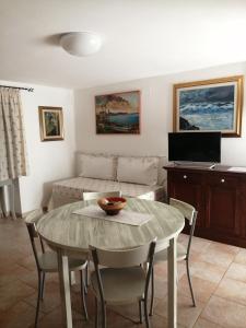 a living room with a table and a couch at Residenza agrituristica Santa Lucia con piscina in Alghero