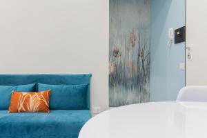 un divano blu con cuscino arancione in una stanza di Aria Marmore a Le Marmore