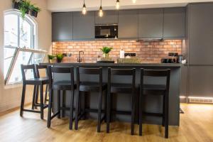 a kitchen with a black bar with black stools at Plymouth Barbican boutique luxury Apartment in Plymouth