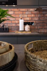 uma cozinha com uma parede de tijolos e um balcão com um cesto em Plymouth Barbican boutique luxury Apartment em Plymouth