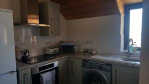 a kitchen with a sink and a washing machine at The Rocks in Westward Ho +22 photos