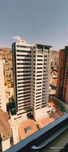 uma vista de um edifício branco alto numa cidade em Moderno y Cómodo Apartamento con la Mejor Ubicación en Sopocachi em La Paz