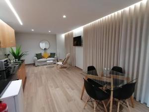 uma sala de estar com uma mesa de vidro e cadeiras em Apartments Madeira Funchal City no Funchal