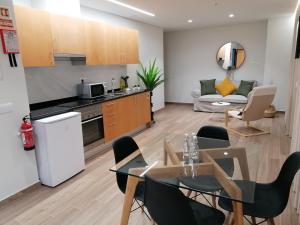 uma cozinha e sala de estar com mesa e cadeiras em Apartments Madeira Funchal City no Funchal