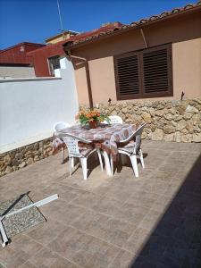 una mesa y sillas en un patio frente a una casa en Casa Nonna Pina, en Fanusa