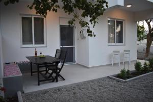 a patio with a table and chairs in front of a house at Pervoli in Faliraki