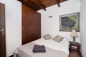 a bedroom with a bed with white sheets and a window at Folwark Żuławski in Elblag