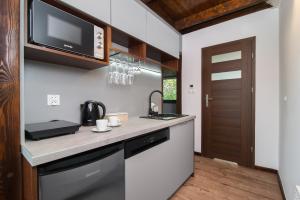 a kitchen with a counter with a sink and a microwave at Folwark Żuławski in Elblag