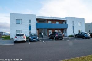 a parking lot with cars parked in front of a building at Comfortable apartment in Vogar