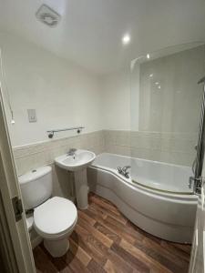 a bathroom with a toilet and a tub and a sink at Orchid Cotswold Stone house in Swindon