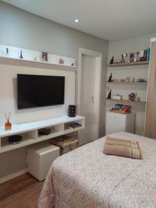 a bedroom with a flat screen tv on a wall at Quarto Inteiro Privado - 3km Oktoberfest in Blumenau