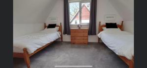 two twin beds in a room with a window at 128 Hengar Manor in Bodmin