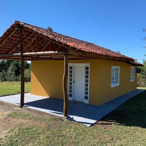 una pequeña casa amarilla con garaje blanco en Sítio AnJo’Z, en Rio Negro