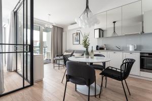a kitchen and living room with a table and chairs at Apartament Chlebova 315 in Gdańsk