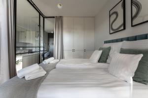 a large white bed with white pillows in a bedroom at Apartament Chlebova 315 in Gdańsk