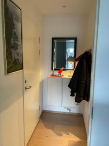 a hallway with a desk with a mirror and a window at Nice apartment in the middel of Tórshavn in Tórshavn