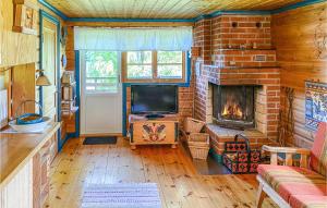 a living room with a brick fireplace and a television at Nice Home In Ludvika With Sauna And 3 Bedrooms in Ludvika