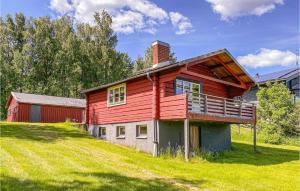 a red house sitting on top of a grassy hill at Nice Home In Ludvika With House Sea View in Ludvika