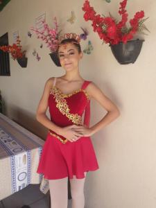 una mujer en un vestido rojo con una corona en la cabeza en Hostel Cidade das Flores 2, en Joinville