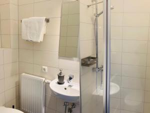 a white bathroom with a sink and a shower at Fährhaus Kirschenland in Jork