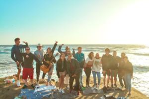 a group of people posing for a picture on the beach at Samesun Ocean Beach Hotel & Hostel in San Diego