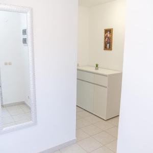 baño con armarios blancos y espejo en Apartment Marin, en Milna
