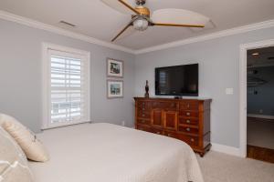 1 dormitorio con 1 cama y TV de pantalla plana en The Anchor Holds by Oak Island Accommodations en Oak Island