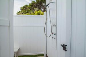 a shower in a white bathroom with a door at Sunkissed 2 by Oak Island Accommodations in Oak Island +67 photos