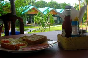 a plate of breakfast food with a bottle of beer at Hongte Khaolak Resort in Khao Lak