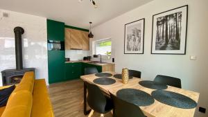 a kitchen and dining room with a table and chairs at Biały Domek Aleja Lipowa 73D in Zwierzyniec