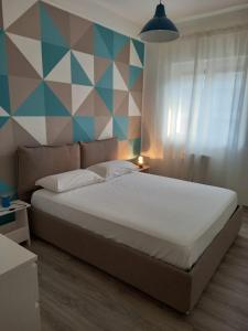 1 dormitorio con cama y pared geométrica en Hauze Trani, en Trani