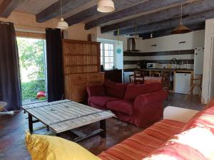 a living room with a couch and a table at Maison au calme sur une propriété de 40 hectares in Bassillac