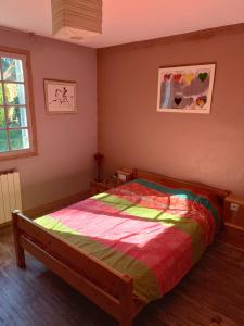 1 dormitorio con 1 cama con un edredón colorido en Maison au calme sur une propriété de 40 hectares en Bassillac