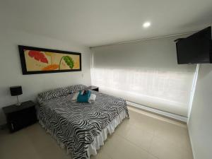 a bedroom with a zebra print bed with a window at Lindos apartaestudios y habitaciones en Ibague in Ibagué