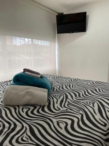 una camera da letto con un letto e un tappeto a motivi zebrati di Lindos apartaestudios y habitaciones en Ibague a Ibagué
