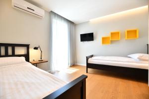 a bedroom with two beds and a tv on the wall at Villa Abyss in Zadar +51 photos