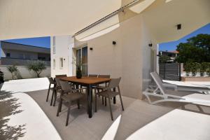 a wooden table and chairs on a patio at Villa Abyss in Zadar
