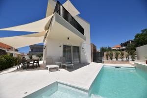 a house with a swimming pool and a patio at Villa Abyss in Zadar