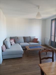 a living room with a couch and a table at Plein centre, T3, 2ch, balcon et vue in Mèze