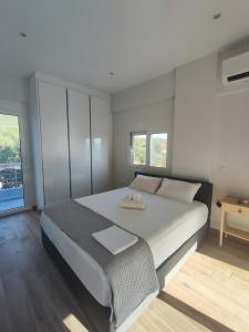 カラマタにあるEvilenia Luxury Apartmentsのベッドルーム1室(大きな白いベッド1台、窓2つ付) +38枚の写真