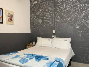 聖保羅的住宿－Studio House Hotel，一间卧室设有粉笔板墙和一张床