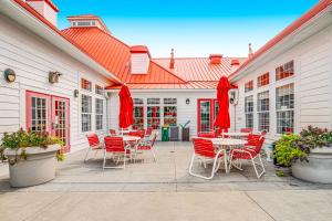 a patio with tables and chairs and red umbrellas at Bayside at Bethany Lakes #143 in Ocean View