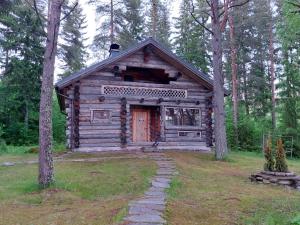 eine Blockhütte inmitten eines Waldes in der Unterkunft Kelola Cottage in Keyritty