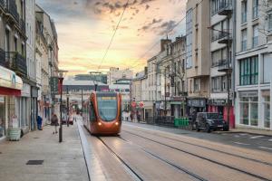 pociąg na torach na ulicy miejskiej w obiekcie Le Mans Appartement Gare TGV et proche centre w mieście Le Mans