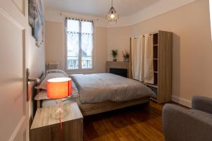 sypialnia z łóżkiem i stołem z lampką w obiekcie Le Mans Appartement Gare TGV et proche centre w mieście Le Mans